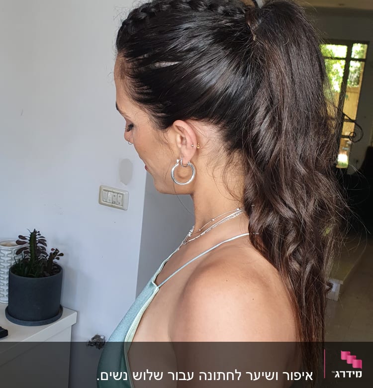 אישה עם שיער אסוף בצמה ופוני גלי